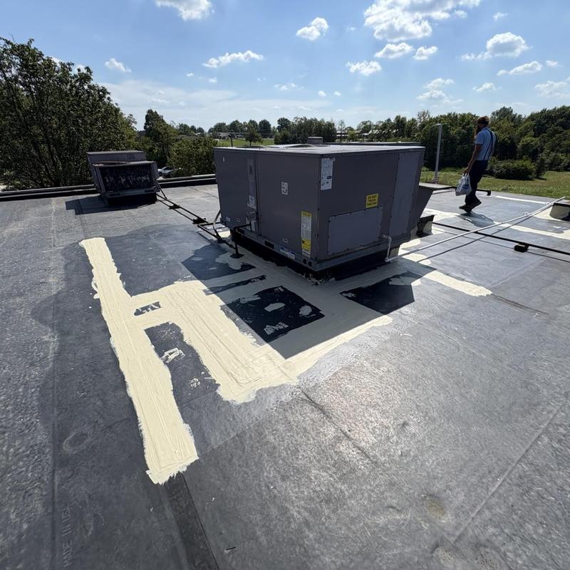 Commercial rooftop HVAC unit with coated sealing around base