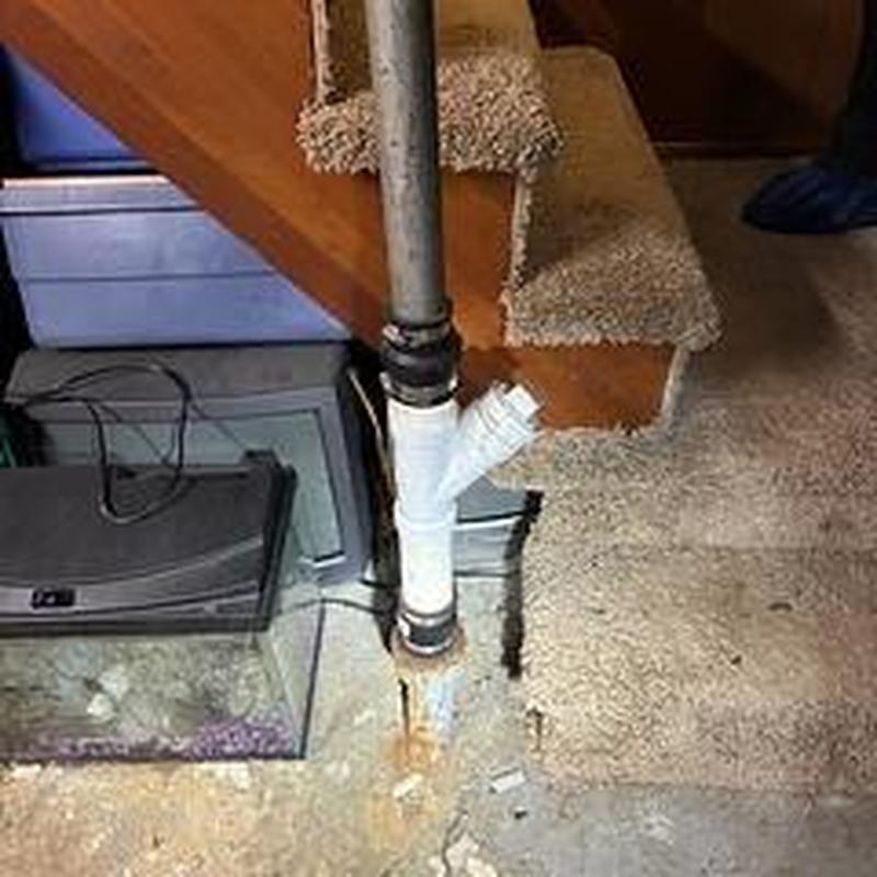 Basement drain pipe with cleanout near carpeted stairs