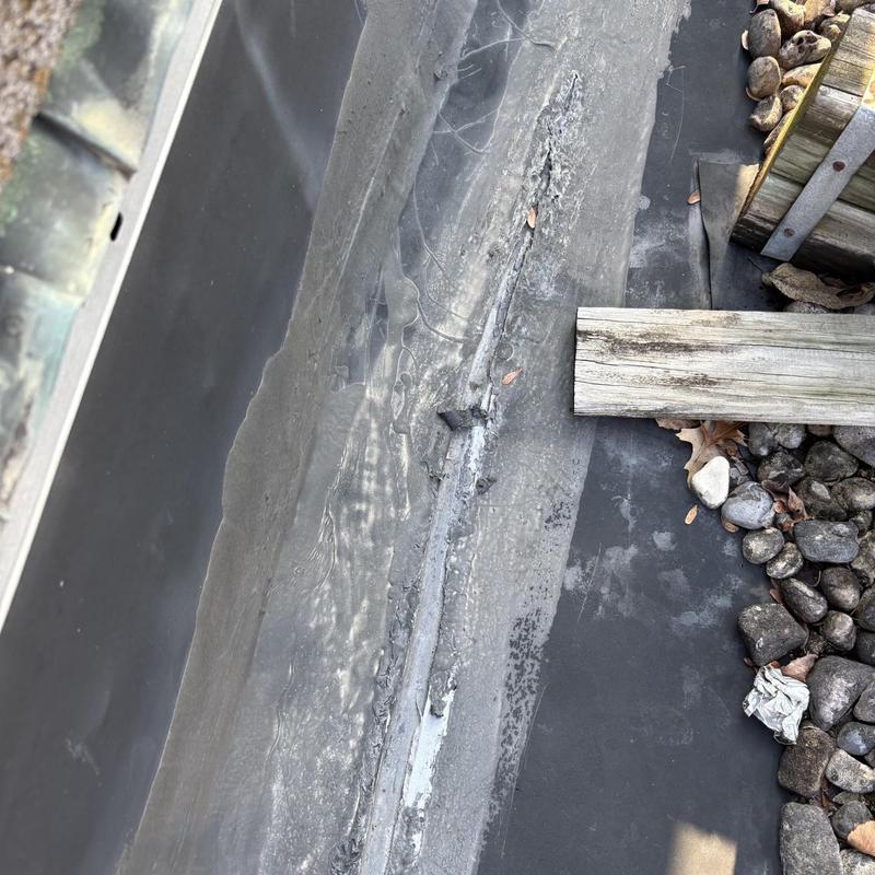 EPDM roof seam with silicone and acrylic repairs
