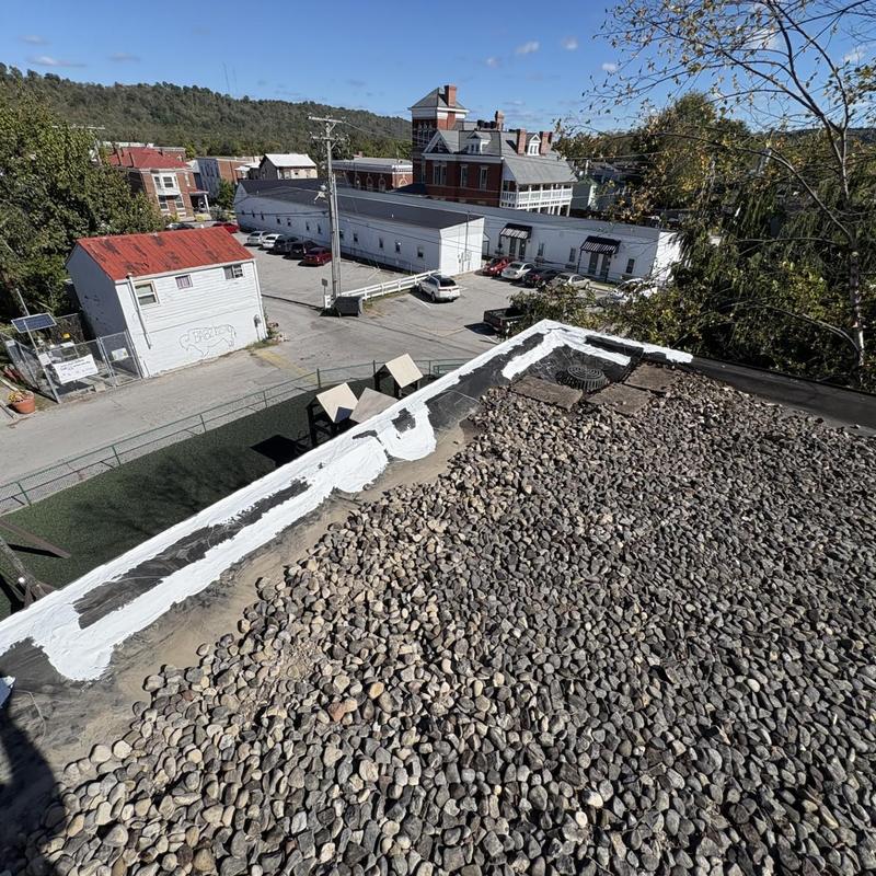 EPDM roof edge with sealant repairs and gravel ballast