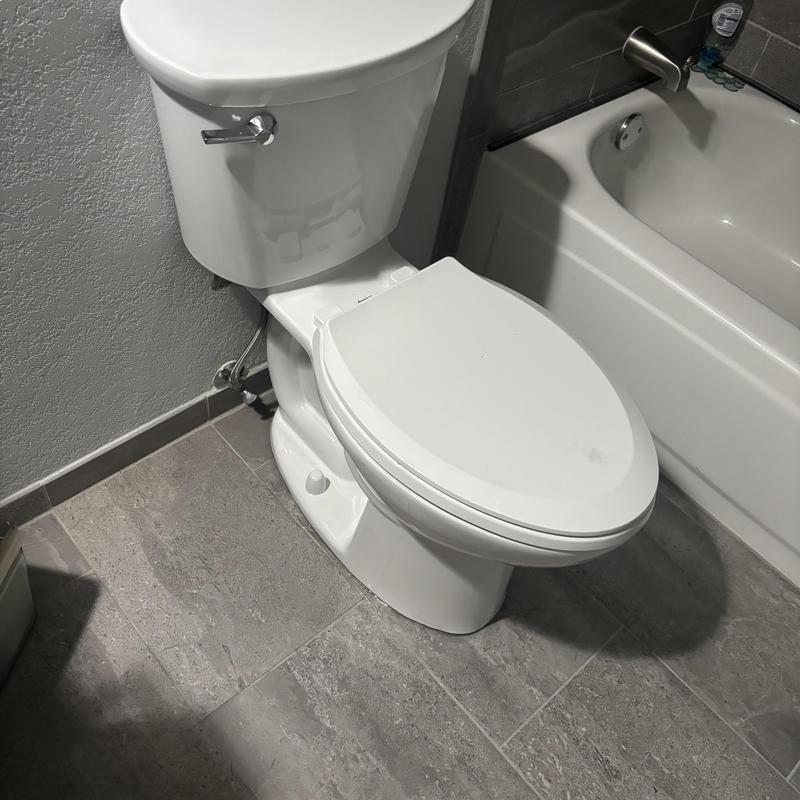 American Standard toilet installed in bathroom corner