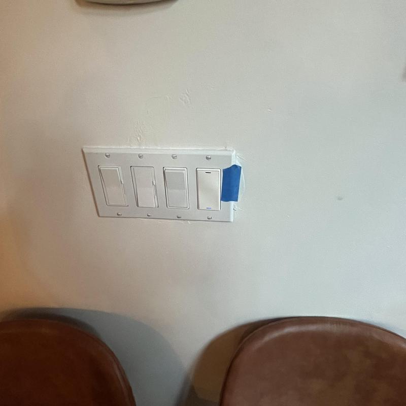 Light switch panel with four switches on wall