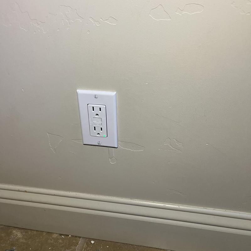 GFCI electrical outlet replacement on beige wall