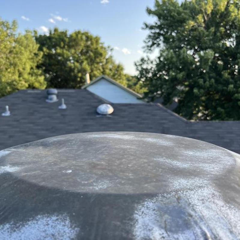 Roof ventilation cap with asphalt shingle roofing background