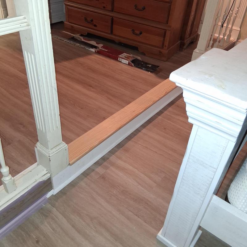 Landing tread and white quarter round molding installation