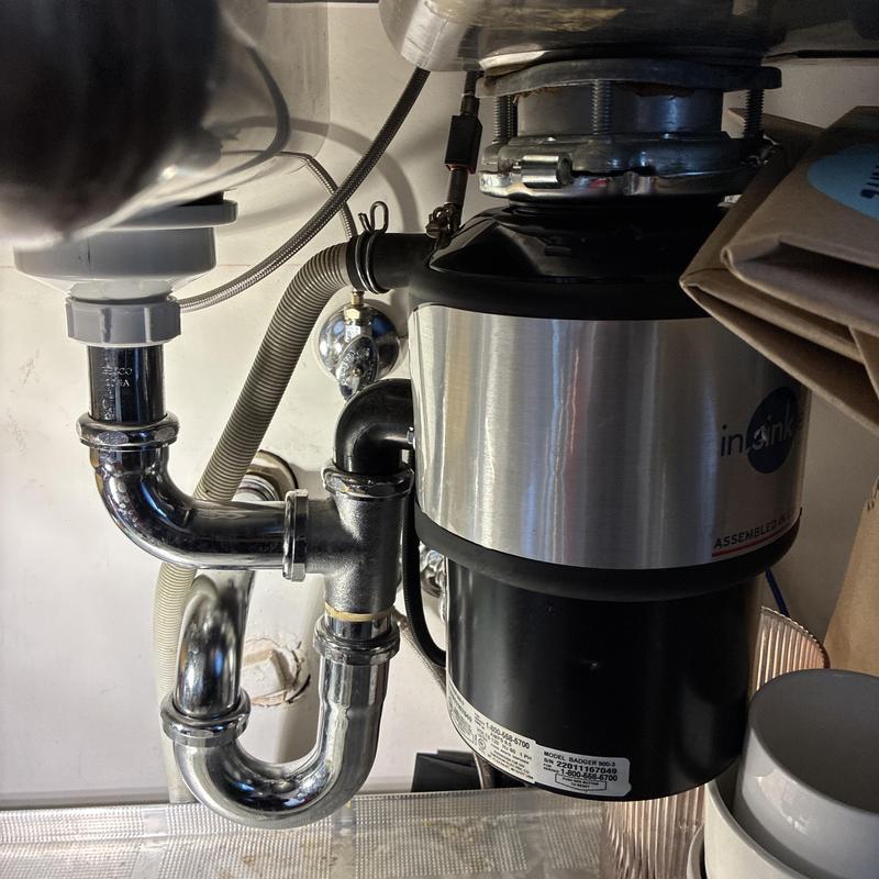 Garbage disposal and sink drain pipes under kitchen sink