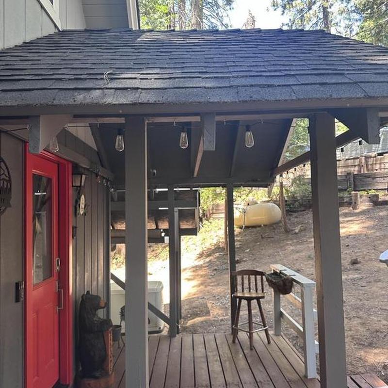 Roof ridge shingles on cabin porch after tree damage