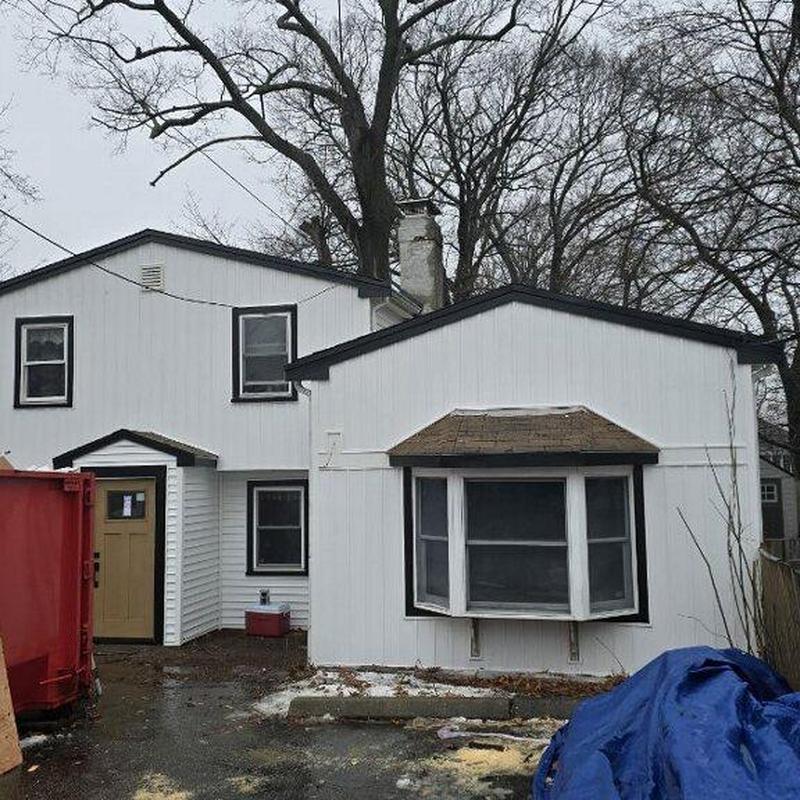 Vinyl siding and aluminum gutter installation on house exterior