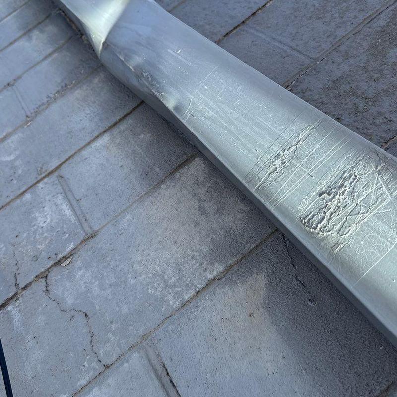 Metal flashing with hail damage on commercial roof