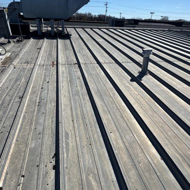 Metal roof panels with hail damage and vent pipe
