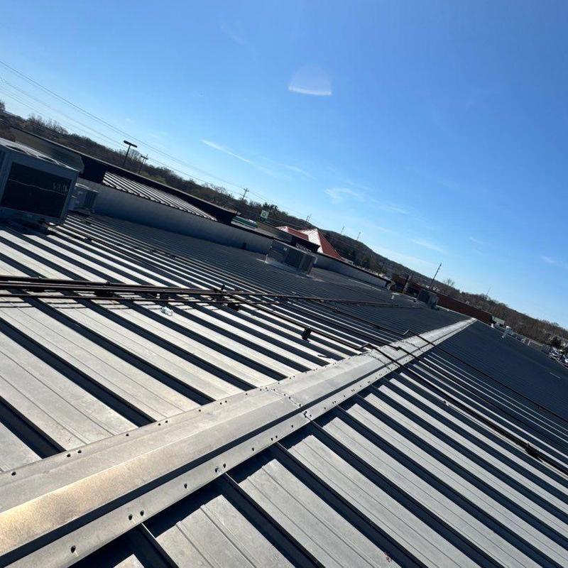 Metal roofing panels and flashing inspection on commercial roof