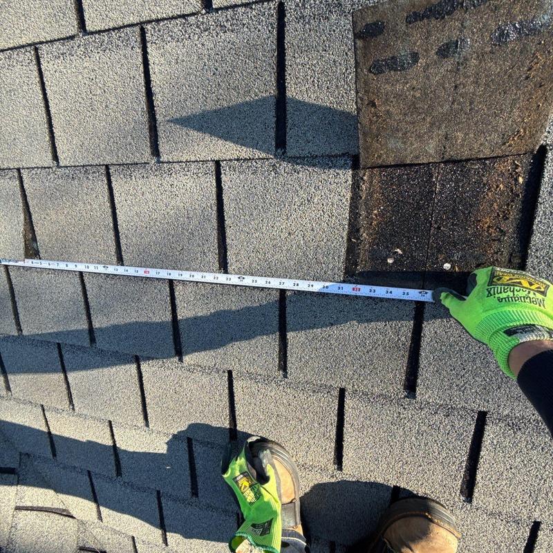 Asphalt shingles with measuring tape for damage assessment