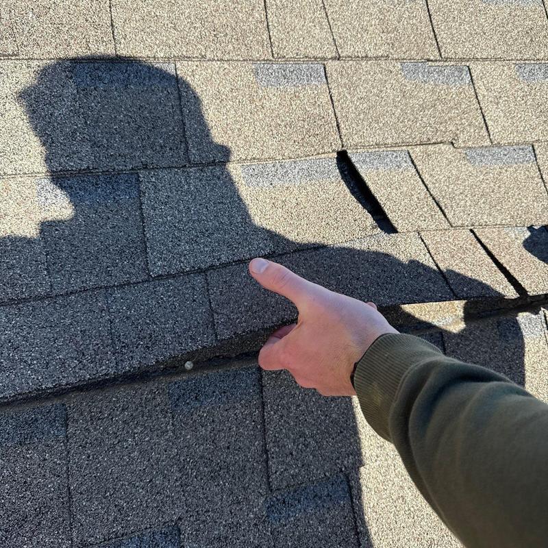 Asphalt shingles with hail damage and lifting edges