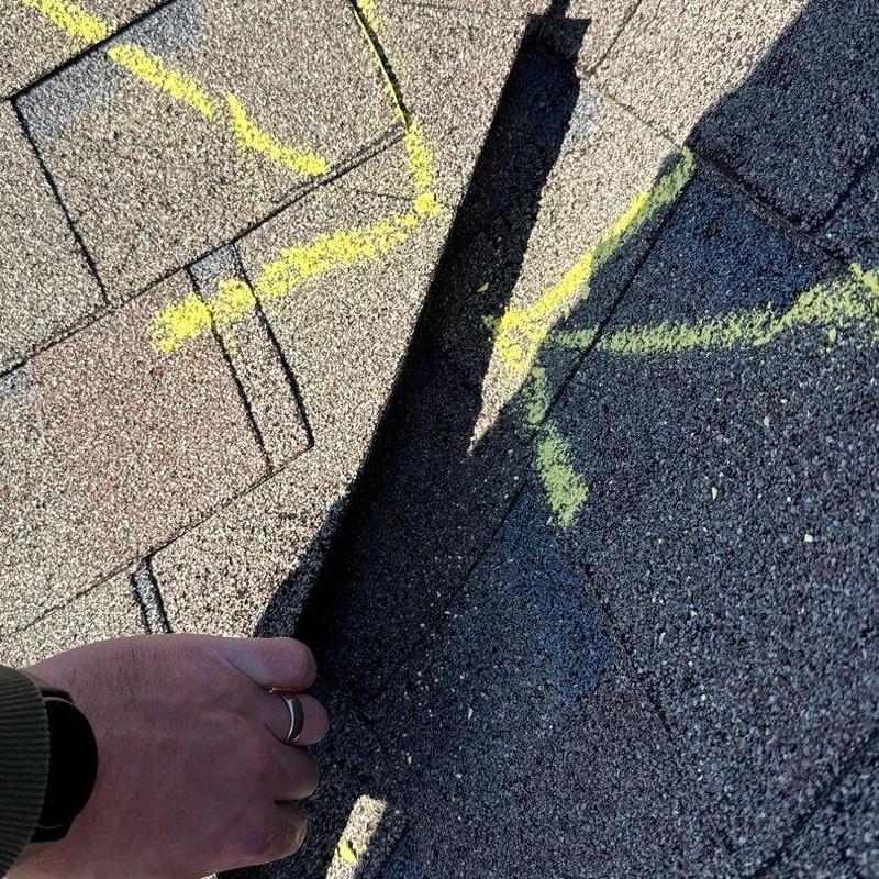 Asphalt shingles with hail damage marked in yellow