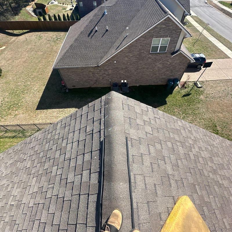 Asphalt shingle roof ridge vent inspection with hail damage