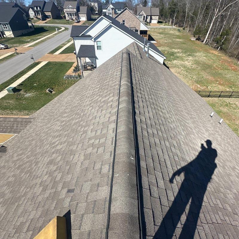 Asphalt shingle roof ridge with inspection shadow