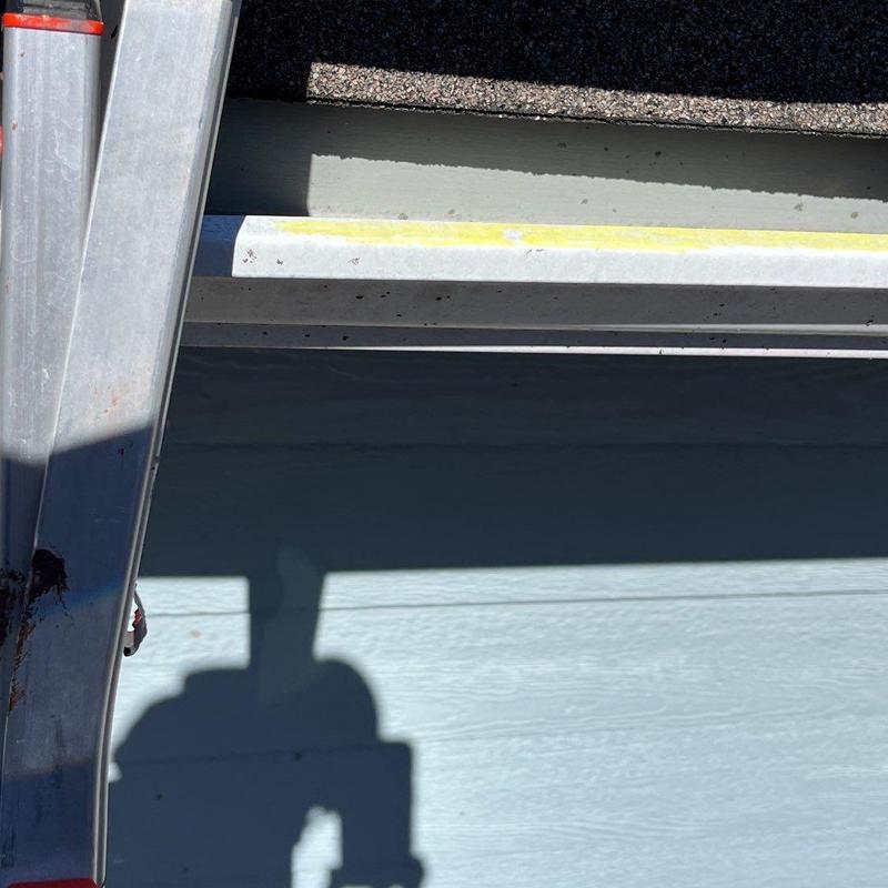 Asphalt shingles roof edge with ladder shadow