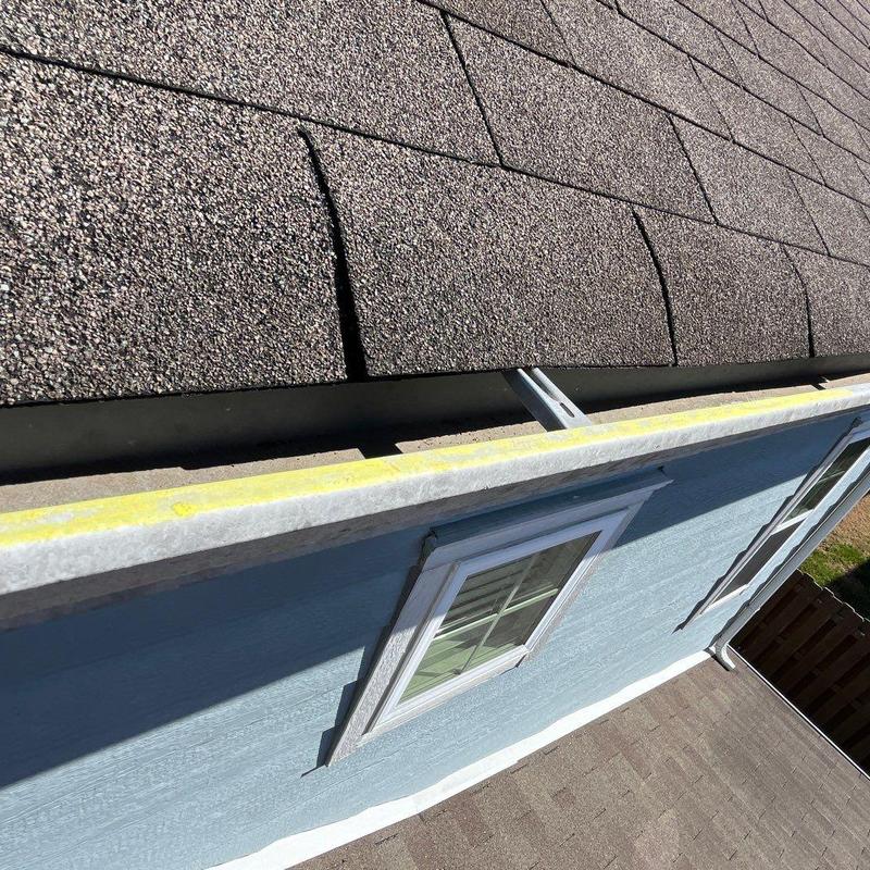 Asphalt shingles with hail damage near gutter edge