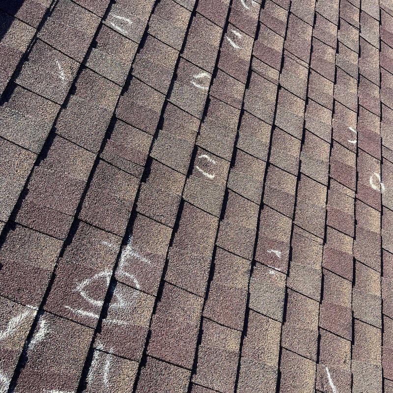 Asphalt shingles with marked hail damage on roof