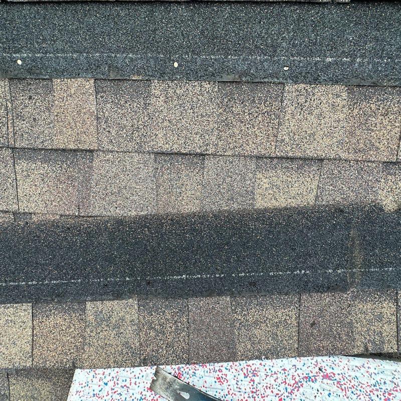 Asphalt roof shingles with visible hail damage close-up