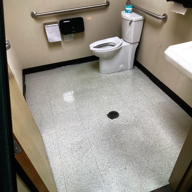 Commercial toilet and floor drain in restroom