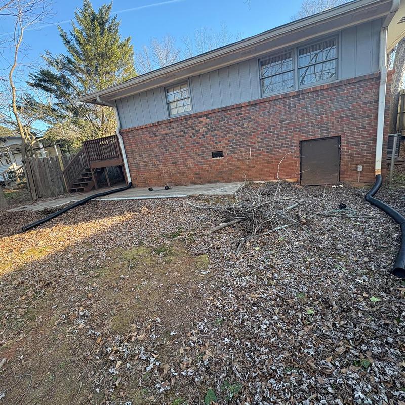 Downspout extensions added to brick house exterior
