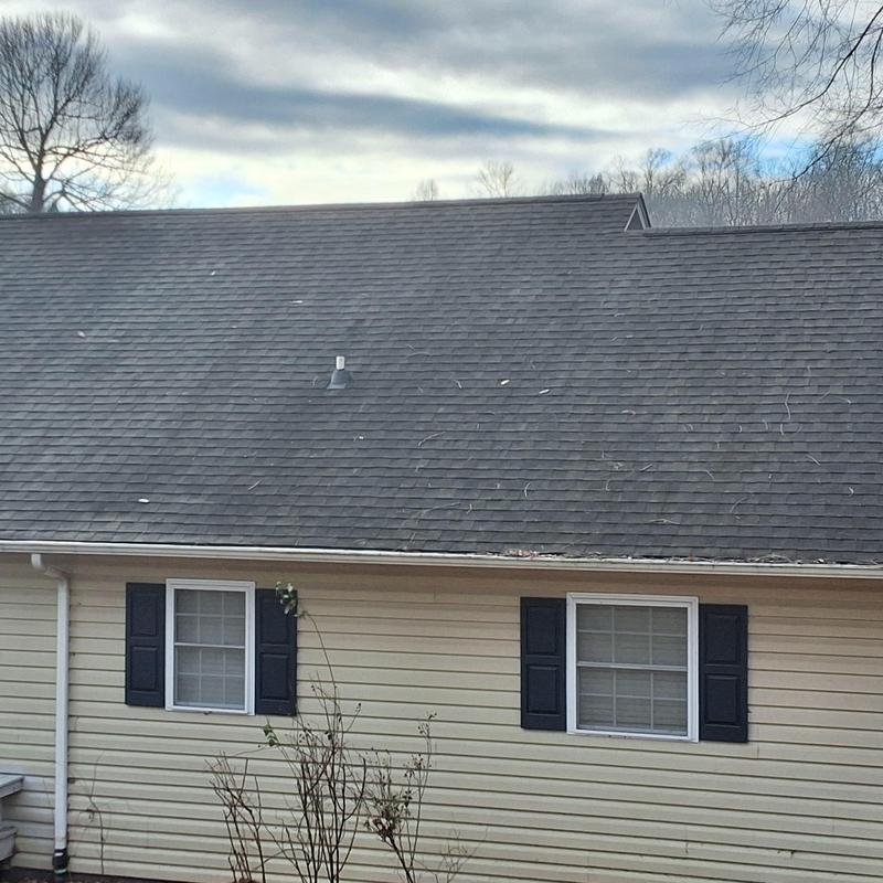 Asphalt shingle roof with aging wear and debris