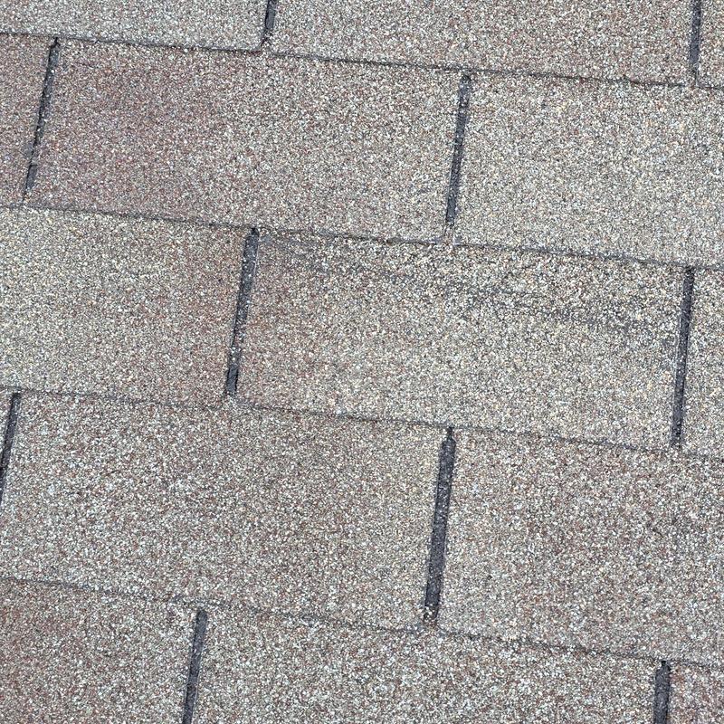 Asphalt roof shingles with hail damage close-up