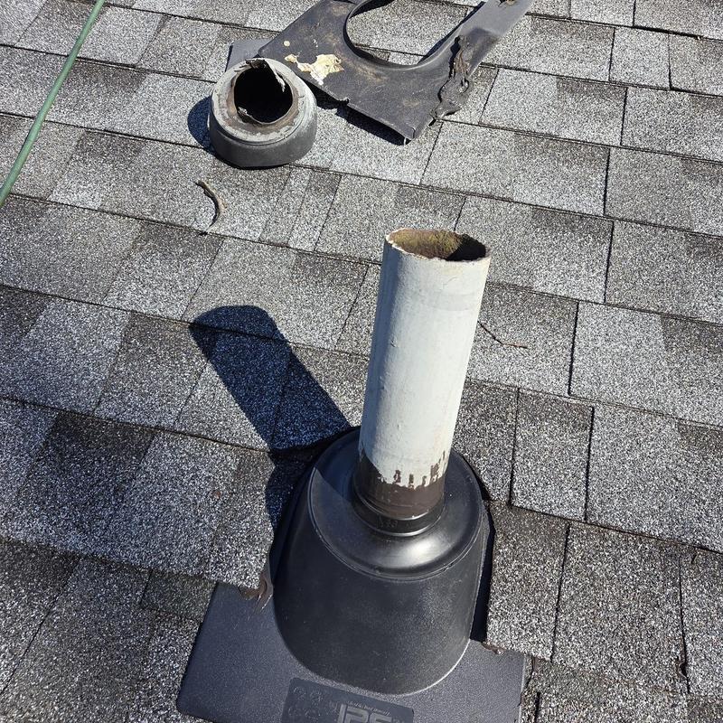 Water heater vent pipe with new pipe boots on shingle roof