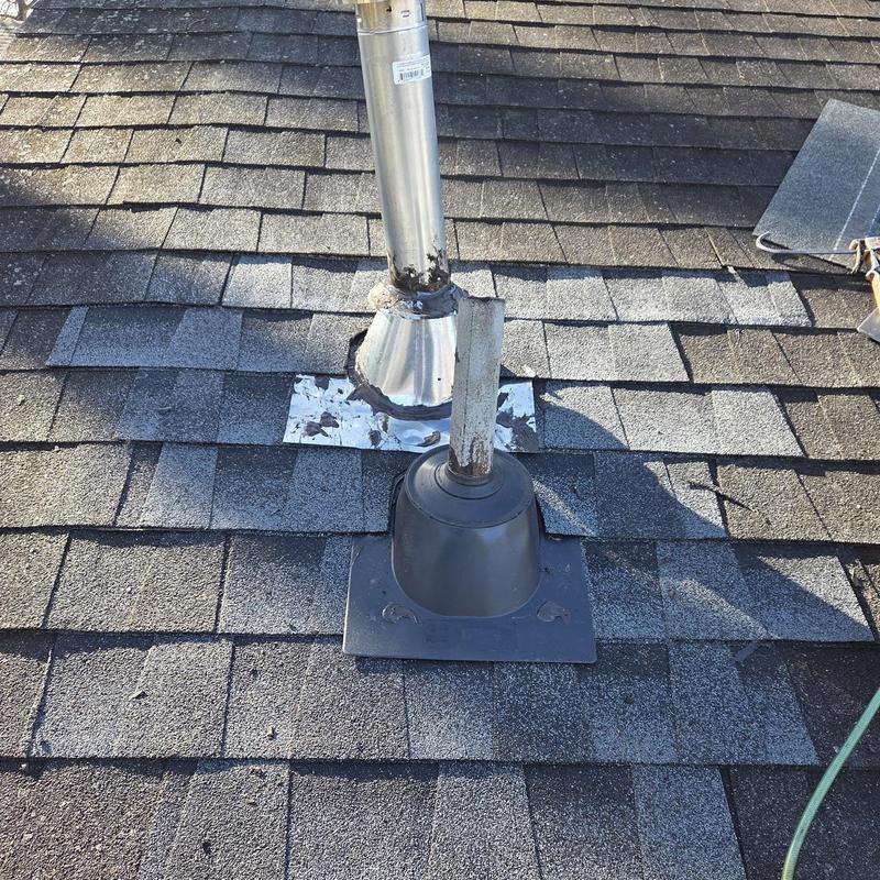 Water heater vent pipe and pipe boot on shingled roof