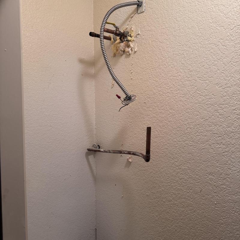 Water heater plumbing lines and gas pipe installation wall