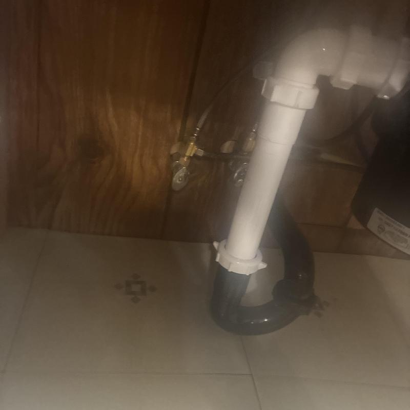 Kitchen sink drain pipes and water supply connections under cabinet