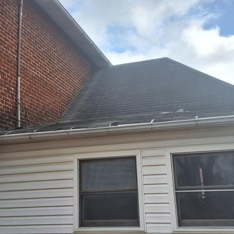 Asphalt shingle roof with white gutter on house exterior