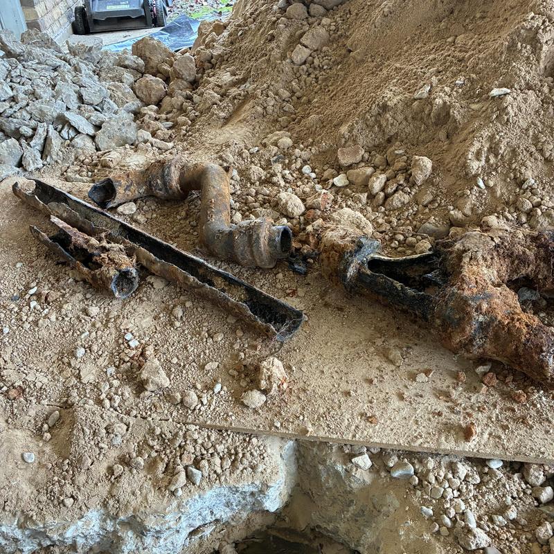 Cast iron drain pipes removed from ground dirt excavation