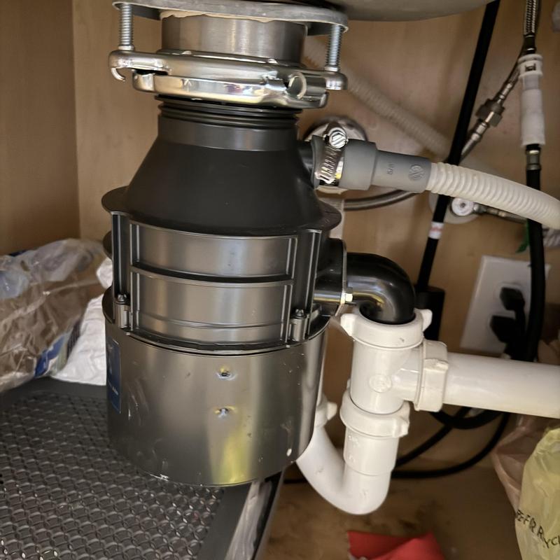 Garbage disposal with plumbing connections under sink