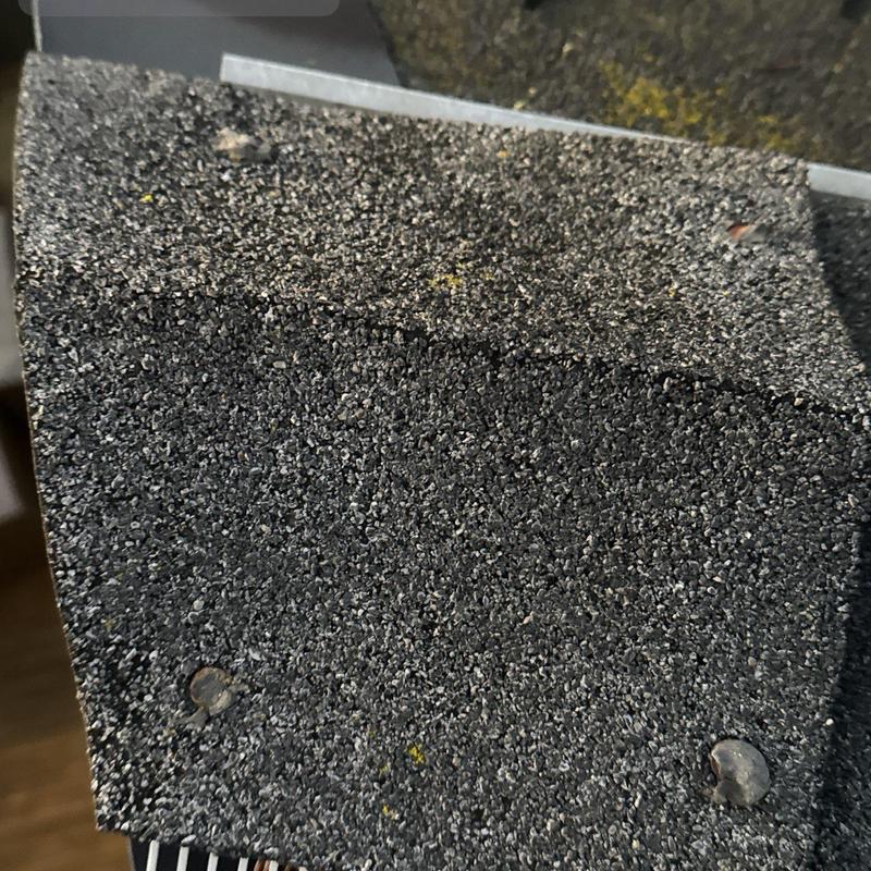 Roof shingle close-up showing fasteners and granules