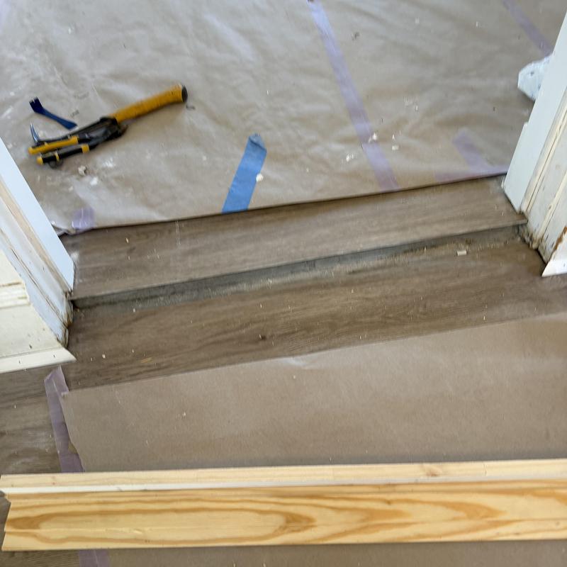 Step board transition with flooring and tools nearby Step board transition with flooring and tools nearby