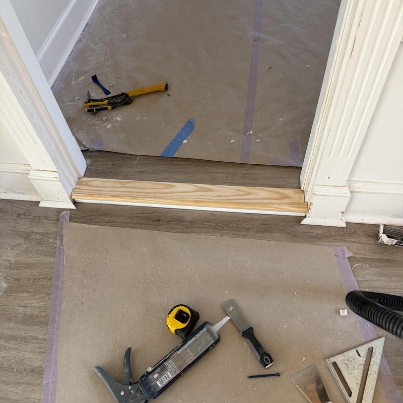 Step board transition with flooring and tools nearby Step board transition with flooring and tools nearby