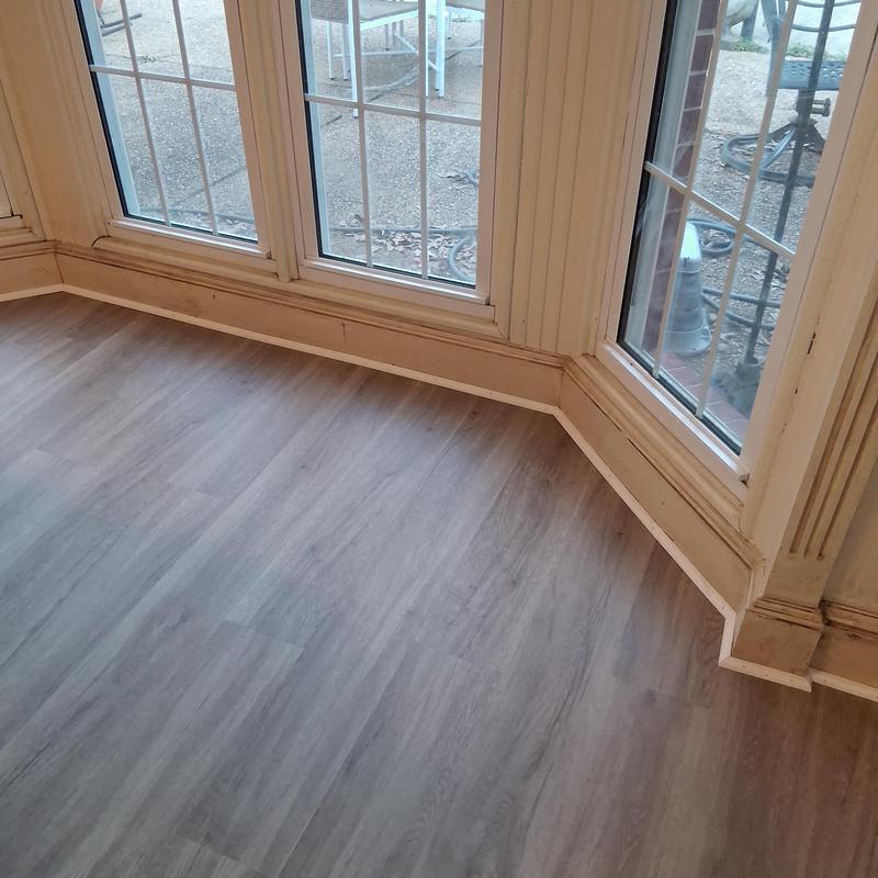 Vinyl plank flooring with shoe moulding near windows
