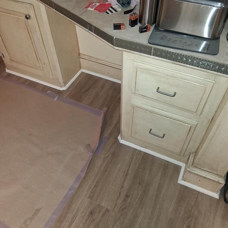 Vinyl flooring and white shoe moulding installation