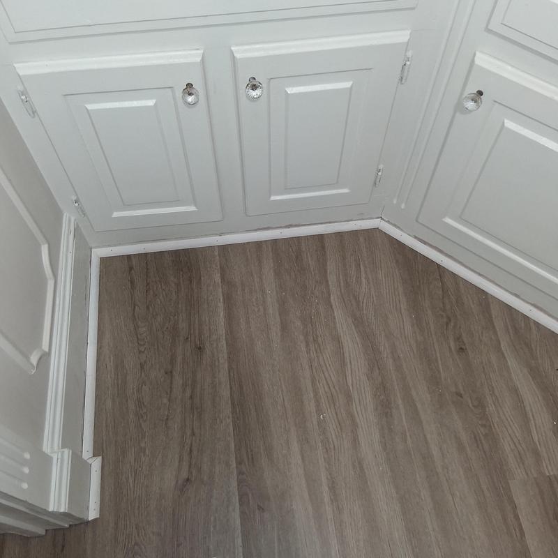 Vinyl plank flooring with white shoe moulding installation