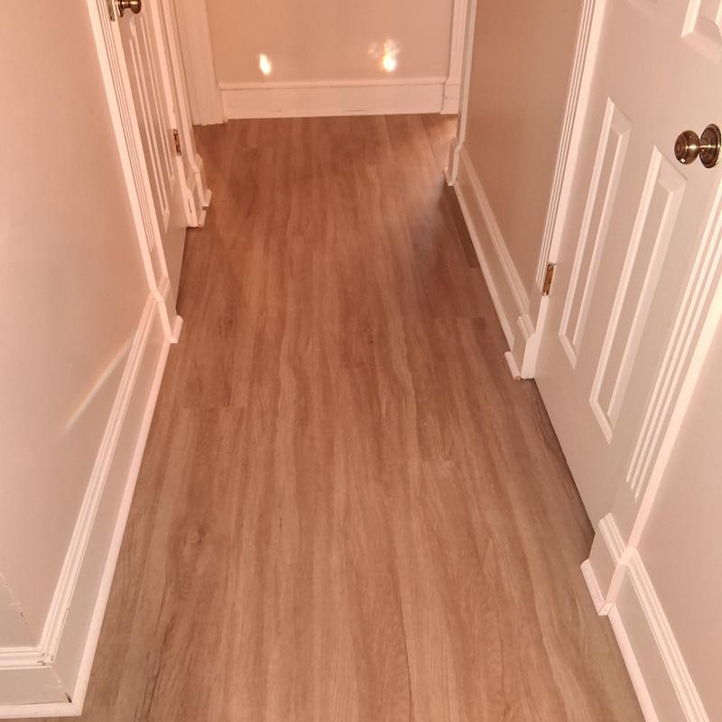 Vinyl plank flooring with white shoe molding installation