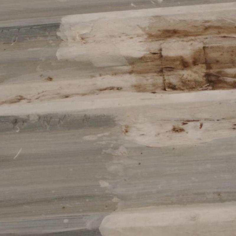 Metal roof panel with rust stains and water damage