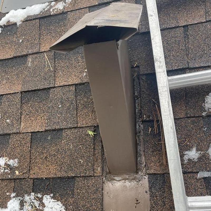 Metal chimney flashing on shingled roof with ladder