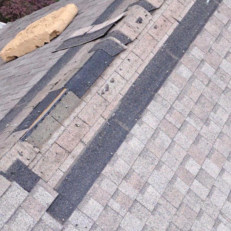 Asphalt shingle roof with hail damage on ridge ridge cap