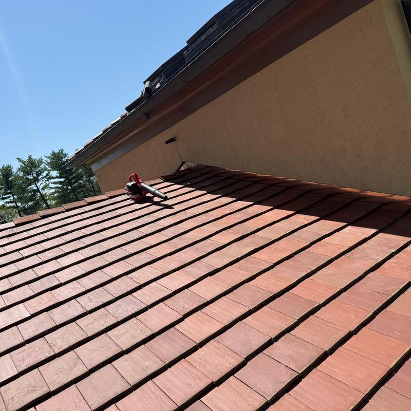 Clay tile roof with blower tool on surface