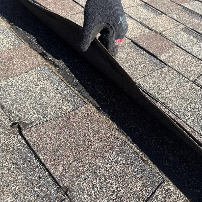 Asphalt shingle lifting to inspect roof underlayment
