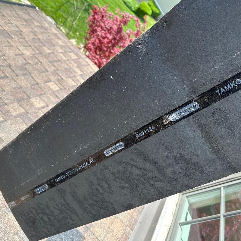 Roof shingle with visible manufacturer's label and markings