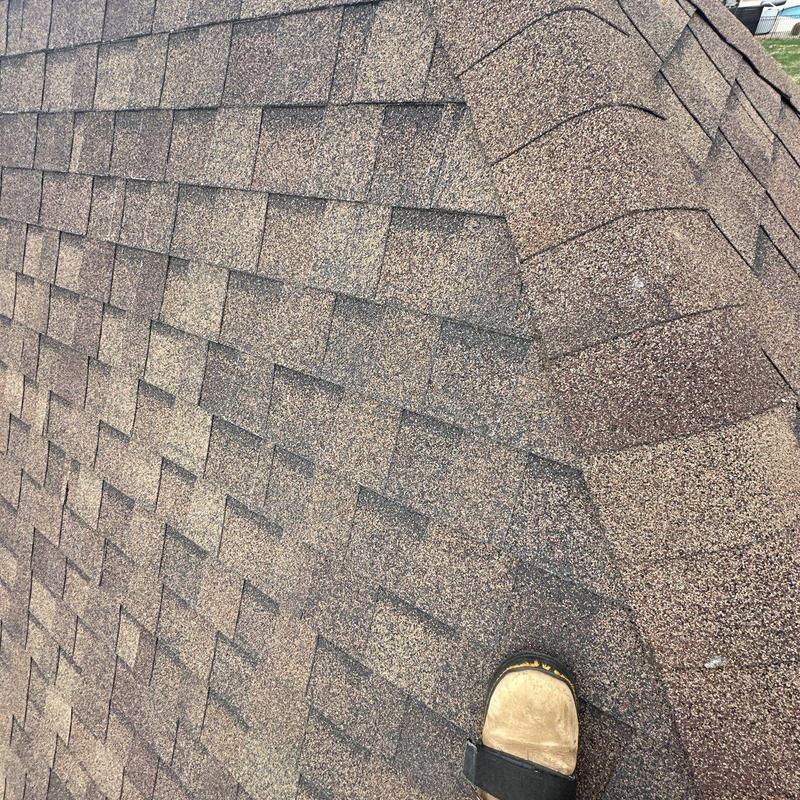 Asphalt shingle ridge cap showing hail damage