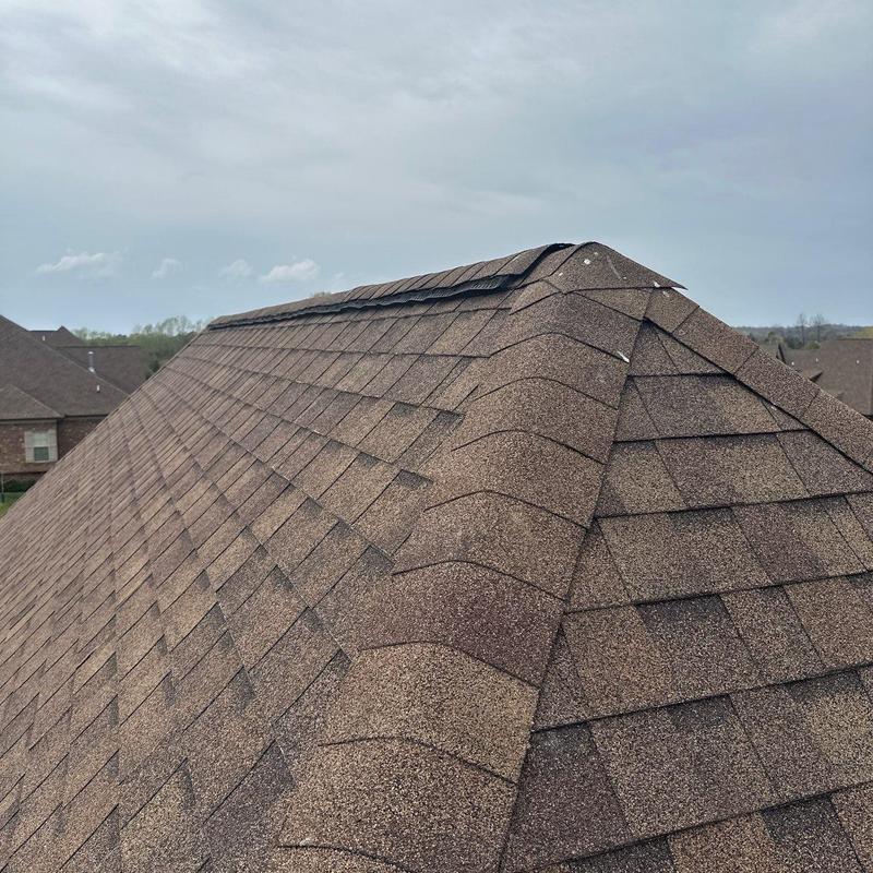 Asphalt shingle roof ridge with hail damage and lifting